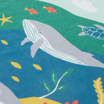 A close up of Frugi Iori Printed T-Shirt in Spring Mint's colourful Sea Life Scene which includes whales and other smaller fish and coral. 
