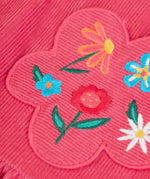 Close up of the flowers embroidery on the front of the Frugi Isla pink rose dungaree dress with.