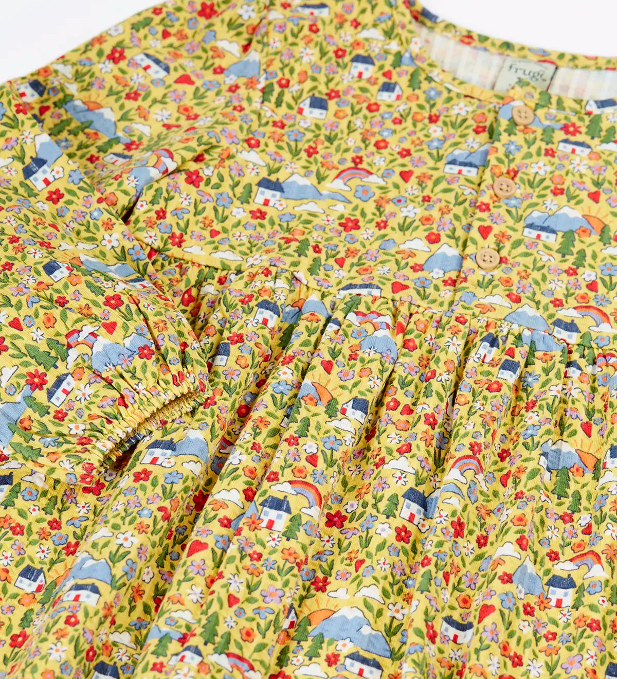 Close up of the elasticated cuffs on the Frugi Izzie organic cotton jersey dress with highland houses print on a yellow background. 