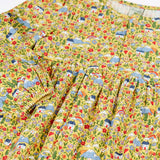 Close up of the elasticated cuffs on the Frugi Izzie organic cotton jersey dress with highland houses print on a yellow background. 