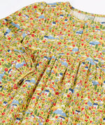 Close up of the elasticated cuffs on the Frugi Izzie organic cotton jersey dress with highland houses print on a yellow background. 