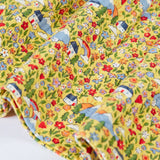 Close up of the hemline on the Frugi Izzie organic cotton jersey dress with highland houses print on a yellow background. 