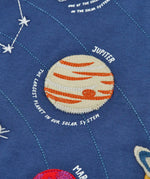 Close up of the Jupiter planet applique on the front of the Frugi Jake long sleeved applique top in navy blue.