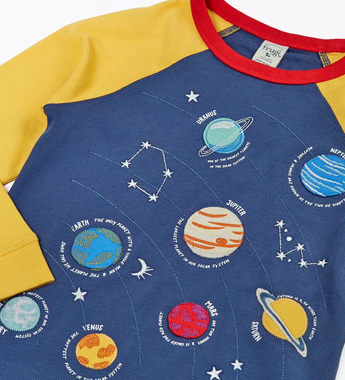 Close up of the Frugi Jake long sleeved applique top in navy blue with yellow sleeves with solar system appliques on the front