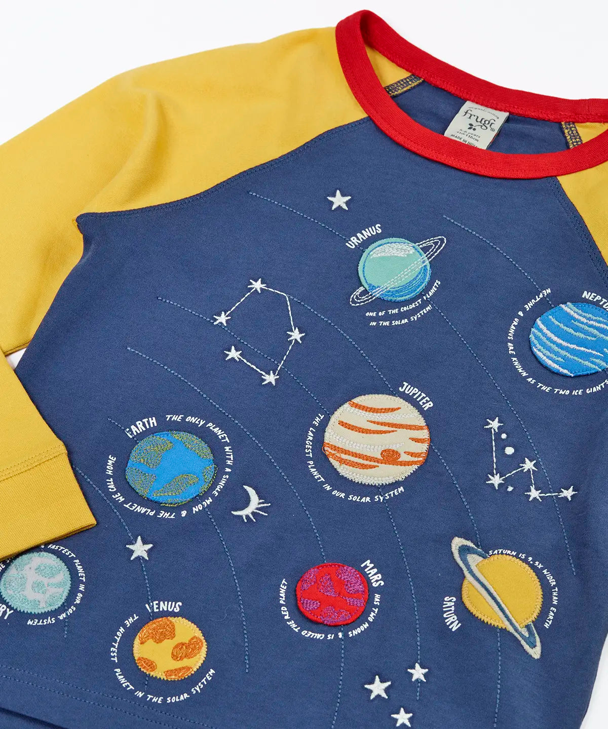 Close up of the Frugi Jake long sleeved applique top in navy blue with yellow sleeves with solar system appliques on the front