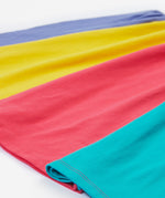 Close up of the Frugi kids jersey rainbow dress - showing the block rainbow bottom half on organic cotton fabric