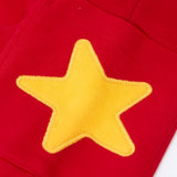 Close up of the yellow star applique on the side pocket of the Frugi journey joggers in scarlet red .