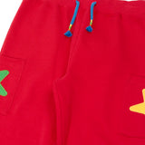 Close up of the front of the Frugi journey joggers in scarlet red with three stars appliques on each side.