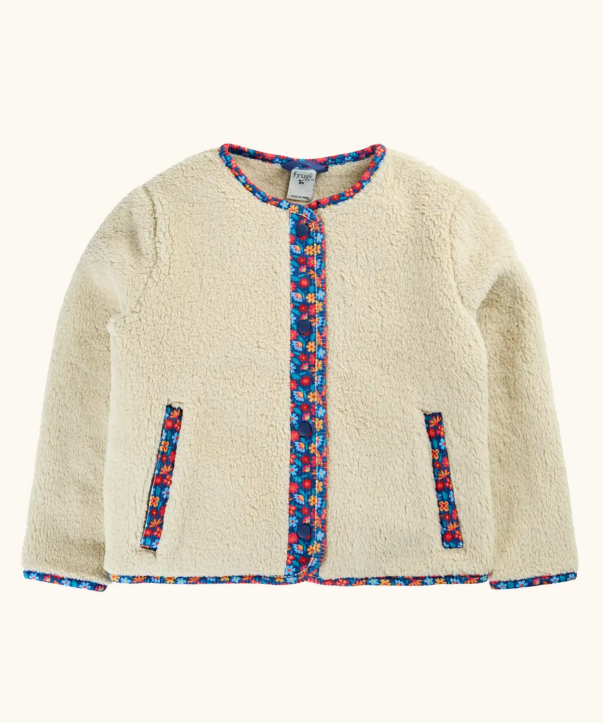 A cream-colored sherpa jacket with colorful floral patterned trim along the front placket, pocket openings, and collar.