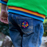 A child with the lets have fun patch from the Frugi keep it wild patch pack on the jeans back pocket 