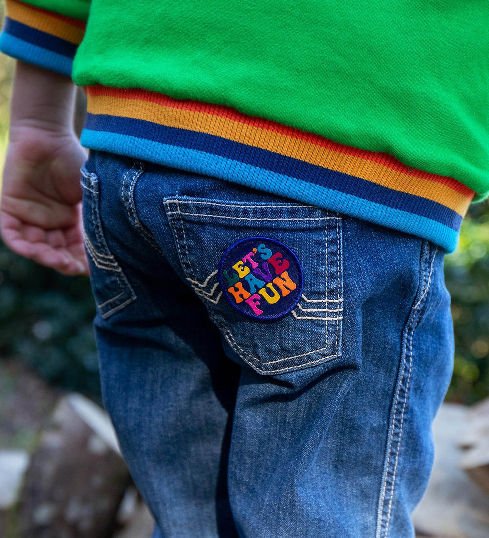 A child with the lets have fun patch from the Frugi keep it wild patch pack on the jeans back pocket 