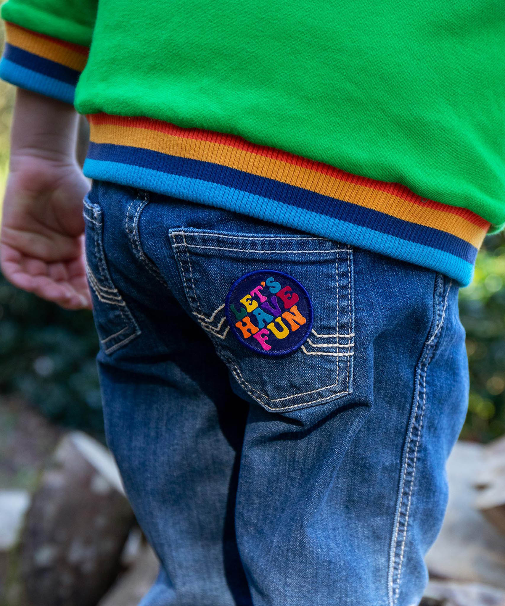 A child with the lets have fun patch from the Frugi keep it wild patch pack on the jeans back pocket 