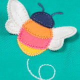 A close up of the Frugi kids carbis hoodie in dragon/bee showing the playful bee appliqué detail on turquoise GOTS organic cotton fabric. 