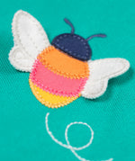A close up of the Frugi kids carbis hoodie in dragon/bee showing the playful bee appliqué detail on turquoise GOTS organic cotton fabric. 