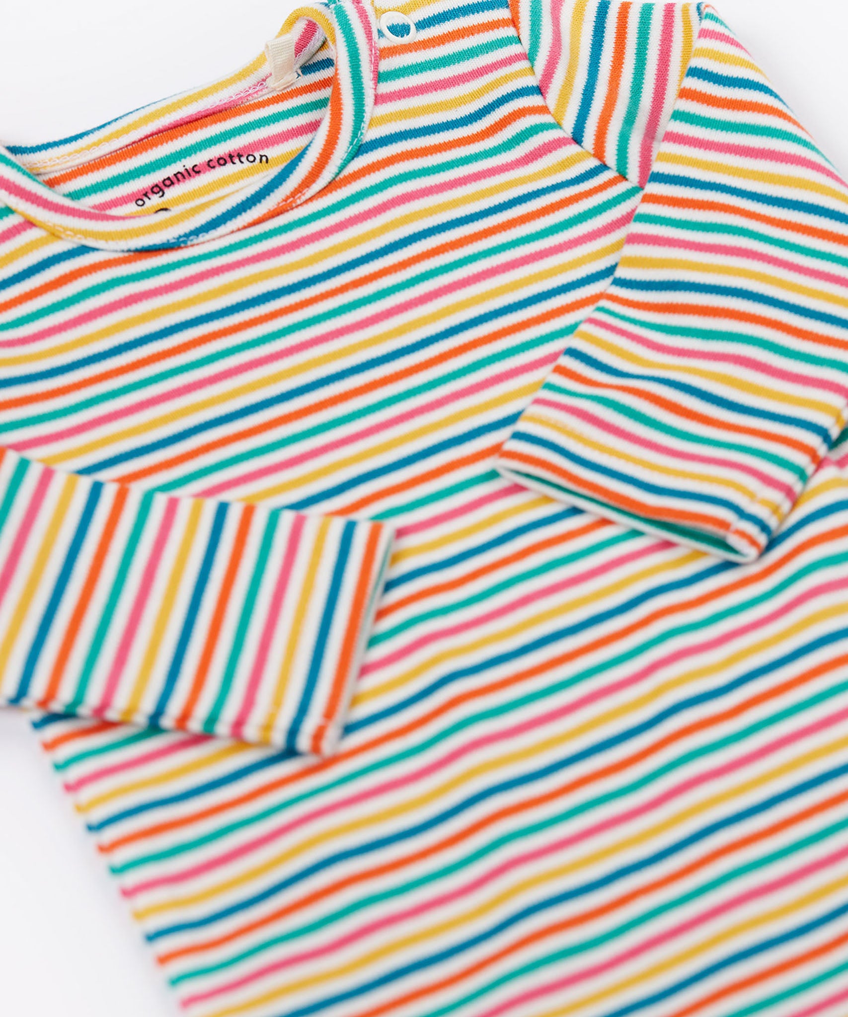 A close up of the Frugi kids multistripe rainbow betty body showing the collar trim and popper fastener detail on the shoulder on organic cotton fabric.