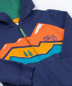 A close up of the Frugi kids carbis hoodie in navy/blue mountain showing the mountainscape applique detail over the full length zip