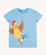 Frugi kids cornflower blue chicken t-shirt. GOTS organic cotton kids t-shirt in light blue and short sleeves. Features an appliqué of a brown chicken standing on a skateboard.