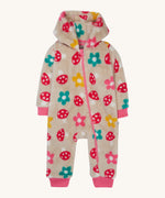 Frugi kids recycled cosy snuggle suit in mushroom fields. A recycled textile all in one suit in a cream colour with a mushroom and flower design. Features a warm cosy hood and a pink trim with matching pink cuffs.