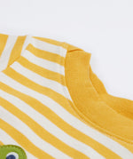 A close up of the Frugi kids wrap around crocodile outfit. Showing the yellow neck trim on yellow and white stripe organic cotton fabric