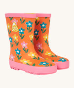 Frugi kids puddle buster wellington boots in fun flower design. A natural rubber, waterproof wellington in orange with pink trim. Features playful prints of multicoloured flowers.