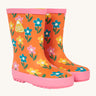 Frugi kids puddle buster wellington boots in fun flower design. A natural rubber, waterproof wellington in orange with pink trim. Features playful prints of multicoloured flowers.