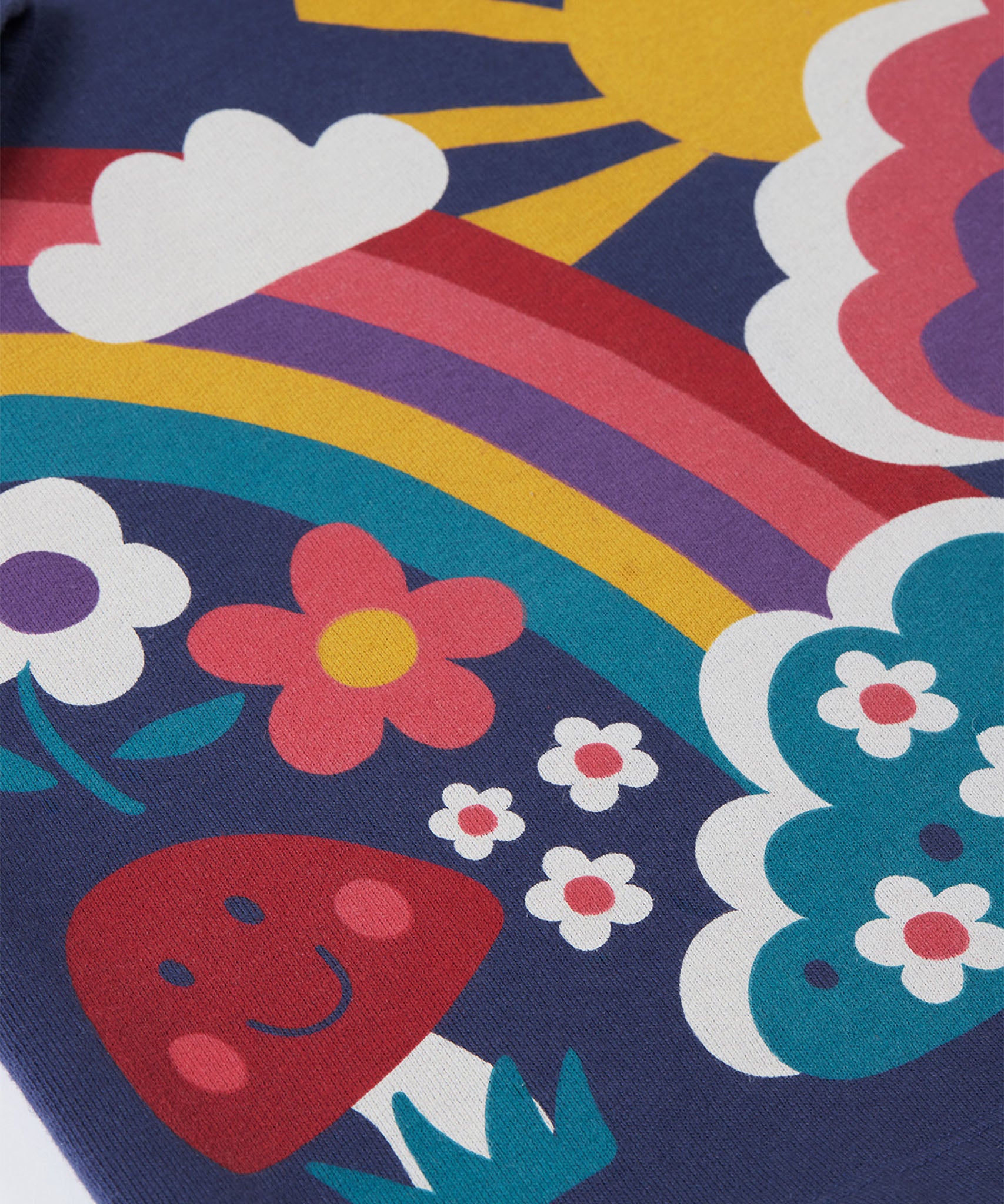 A close up of the Frugi kids kari dress in navy/rainbow showing the playful woodland inspired print detail on organic cotton fabric.