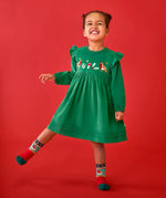 Child wearing the Frugi organic cotton maud holly green corduroy dress with embroidery robin details on the chest and shoulder frills with robin socks.