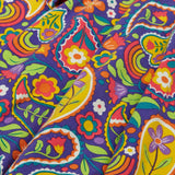 Close up of the folds on the skirt on the Frugi GOTS organic cotton sofia skater dress in pretty paisley. Purple background with colourful paisley print featuring flower and rainbow details.