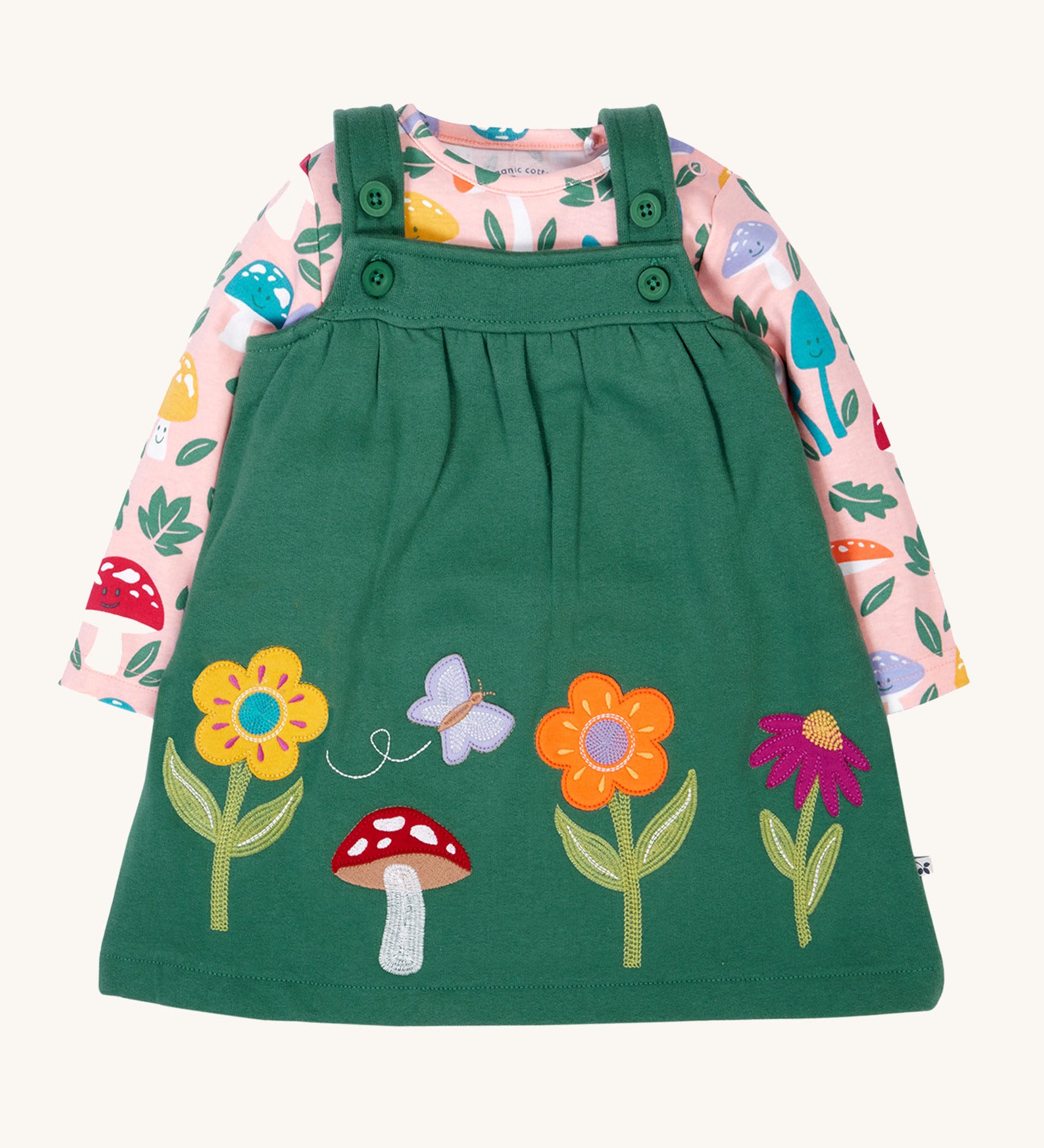 Frugi kids pippa holly green fun guys pinafore outfit available at Babipur. a 100% GOTs organic cotton outfit. Features a pink long sleeve top with cute woodland inspired prints and a green pinafore with flowers, mushroom and a bee applique 