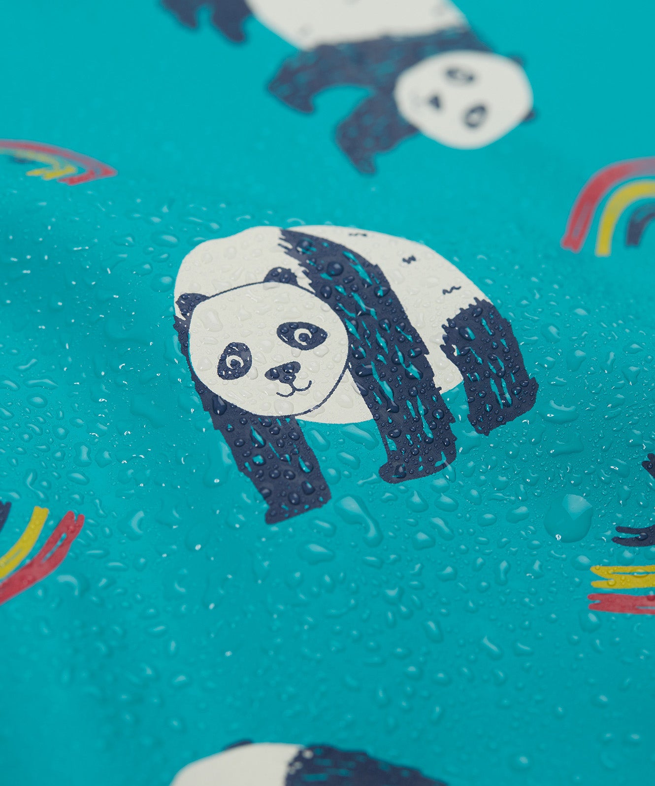 A close up of the panda print on the Frugi panda play puddle buster all in one showing water on the waterproof material 