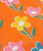 A close up of water on the Frugi puddle buster fun flowers coat showing the waterproof feature 