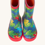 A top down view of the Frugi kids puddle buster wellington boots Showing the the red trim and playful frog print detail on navy natural rubber material. 