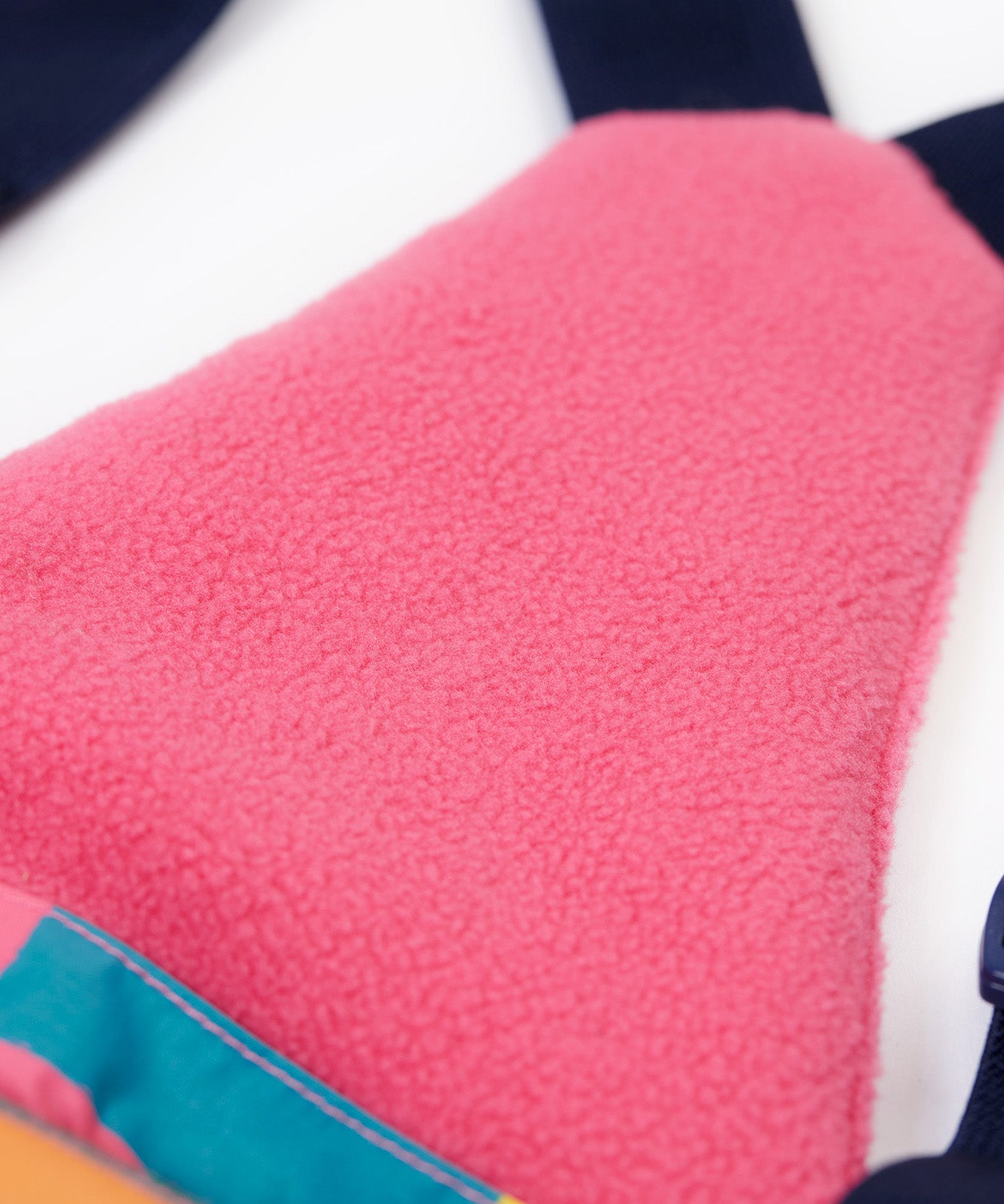 A close up of the Frugi penguin waddle snow and ski salopettes showing pink fleece detail on the bib attached to the back