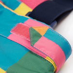 A close up of the Frugi penguin waddle snow and ski salopettes showing adjustable waist band detail on a bright check recycled polyester fabric