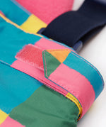 A close up of the Frugi penguin waddle snow and ski salopettes showing adjustable waist band detail on a bright check recycled polyester fabric