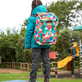 View of the back of a child wearing the Frugi kids 3 in 1 rambler coat in boat blue rhubarb check with a colourful Frugi Trail Blazing fun frenzy backpack on her back.
