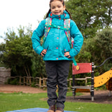 Child wearing the Frugi kids 3 in 1 rambler coat in boat blue rhubarb check with a Frugi Trail Blazing fun frenzy backpack on her back.