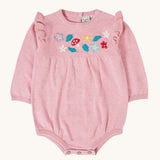 Frugi kids remi knitted romper in pink marl /flowers available at Babipur. A GOTS organic cotton soft knitted romper suit with long sleeves and frilled shoulders. Features button fasteners at at crotch and woodland inspired embroidery on the front.