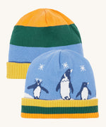 Frugi reversible voyager hat in penguin/ rainbow. A GOTS organic cotton cosy hat with a cute penguin design on blue with a yelow, green and orange striped ribbed trim and a matching bold stripe on the reverse side. 
