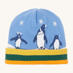 A close up of the Frugi reversible voyager hat showing the penguins under a starry sky design on blue GOTS organic cotton fabric with a yellow, green and orange soft ribbed trim.