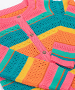 A close up of the Frugi kids rowe rainbow cardigan in rainbow/pointelle showing the button and soft patterned knit detail.