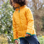 A child wearing the Frugi Children's Reversible Toasty Trail Jacket - Safari Camo