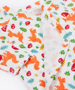 A close up of the Frugi shay body 2 pack in squirrel play/soft white showing the cute playful squirrel print and popper fastener detail on organic cotton fabric.