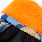 A close up of the Frugi kids penguin waddle snow mittens showing the black grippy palm and orange fleece inner for warmth 