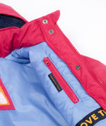 A close up of the Frugi kids 3 in 1 rambler coat in snapdragon /navy colourway showing the hidden side pocket and pink zip detail on the inside of the coat on lilac post consumer recycled polyester fabric
