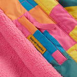 A close up of the Frugi kids snow and ski coat in rainbow check showing the hidden pocket on the inside and pink fleece detail