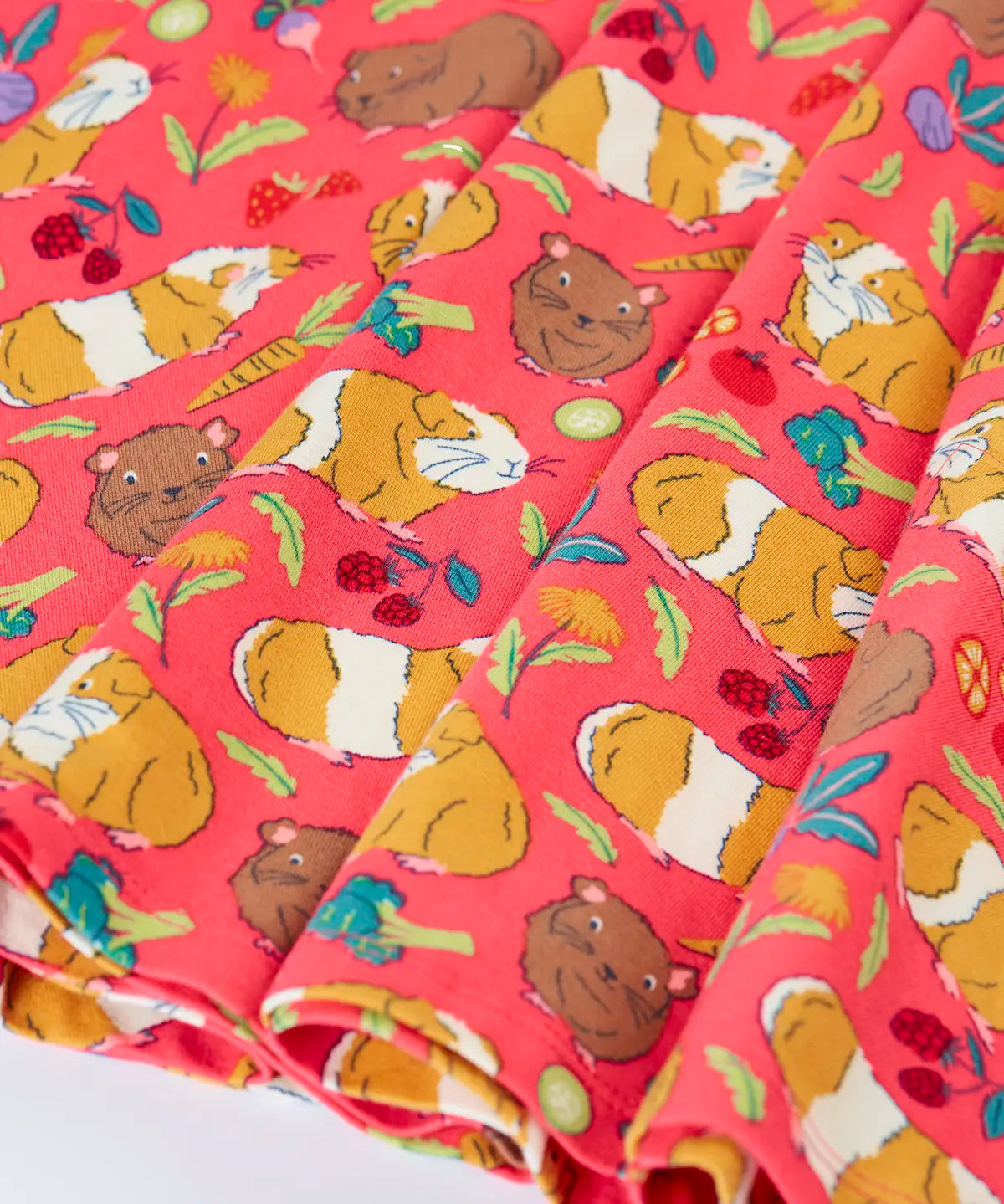 Close up of the skirt on the Frugi Sofia skater dress in pink with an all over guinea pig muddle print. 