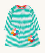 Frugi kids tammy dress in dragon stripes/flowers available at Babipur. A 100% GOTS organic cotton dress with long sleeve in light blue and white stripes with pink trim. Features 2 playful flower appliques on the skirt.