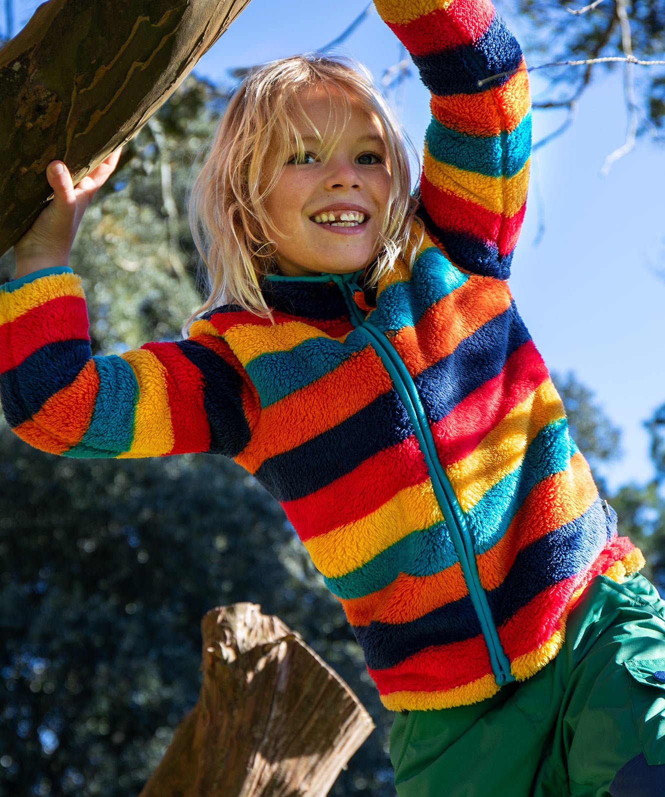 A child wearing the Frugi Autumn stripe ted fleece. A long sleeve striped thick fleece with light blue trim and turn up collar.