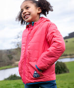 A child wearing the Frugi toasty trail reversible jacket showing the light pink coloured with pink zip detail and a brand patch on the side pocket on post consumer recycled polyester fabric.